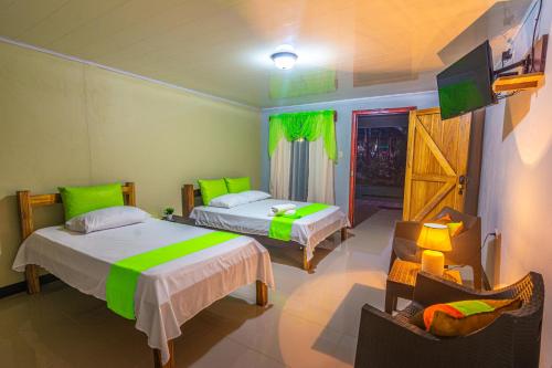 比加瓜Rio Celeste Springs Blue Lodge的一间酒店客房,设有两张床和电视