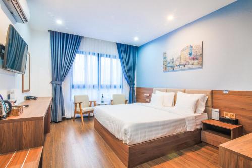 胡志明市Grand Lee Hotel的配有一张床和一张书桌的酒店客房