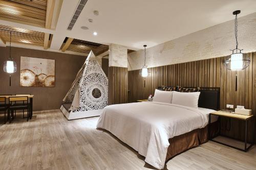 高雄歐閣精品汽車旅館-簡愛館的一间卧室配有一张大床、一张桌子和一把椅子