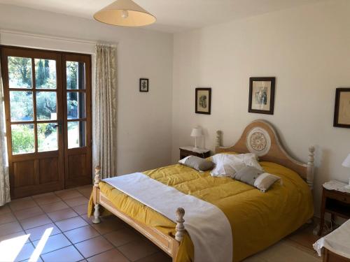 FauconLe Mas de Fanny的一间卧室配有一张带黄色毯子的大床