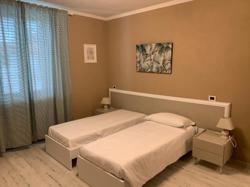 利沃诺Locanda il Deserto的一间卧室设有两张床和窗户。
