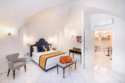 阿马尔菲Amalfi Resort的一间卧室配有一张床、一张桌子和一把椅子