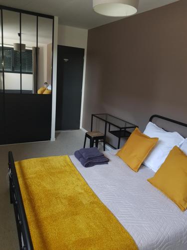 亚眠Escapade Amiens的一间卧室配有一张带黄色枕头的大床