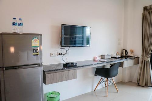 奈扬海滩S2机场公寓酒店的厨房配有书桌、电视和椅子