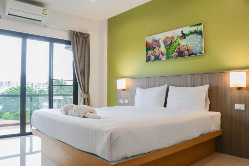奈扬海滩S2机场公寓酒店的卧室设有一张大白色的床和大窗户