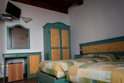 卢戈La Locanda dei Gagliardi的一间卧室设有三张床、镜子和电视