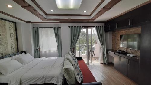 碧瑶Gab's CozyHome at Bonbel Condo, Botanical Gardens Baguio的一间卧室设有一张床和一个大窗户