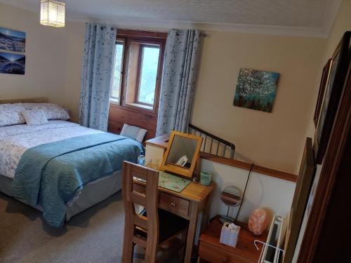 霍姆弗斯Pellcroft Cottage的一间卧室配有一张床和一张带镜子的书桌