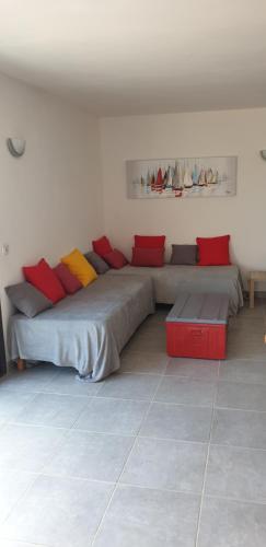 卡尔热斯Soluna的客房设有两张带红色和黄色枕头的床。