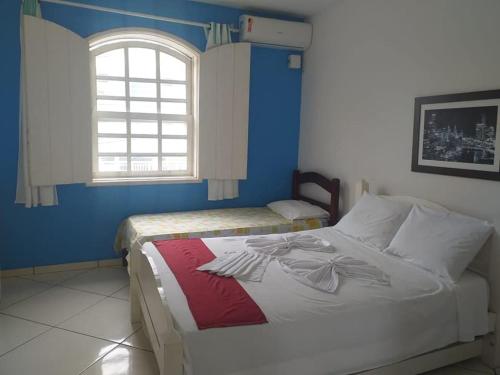 萨夸雷马Pousada Garota De Itauna的一间卧室设有两张床和窗户。