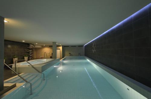鲁哈科维斯博豁达酒店的大楼内带蓝色灯光的大型游泳池