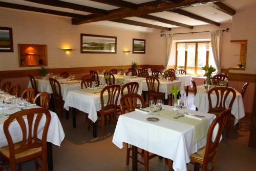 圣谢利多布拉克旅行者酒店的餐厅配有桌椅和白色的桌布