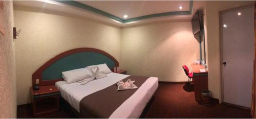 墨西哥城HOTEL ORION的酒店客房,配有一张带弓的床铺