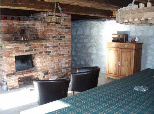 HaeskaTuulingu Holiday House at Matsalu National Park的客房设有砖砌壁炉、桌子和椅子。