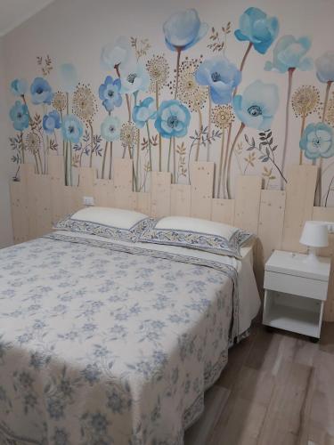 MontescanoLa Casa Colonica的卧室配有一张挂着蓝色鲜花的床。