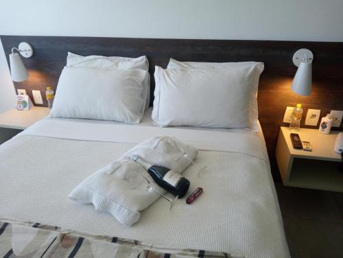 马塞约Flat Suites em Hotel de Luxo的酒店客房,配有一张带电话的床