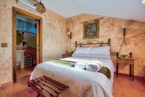 鲁伊德拉Casa Rural La Torca Ruidera的一间卧室设有一张大床和一张木凳