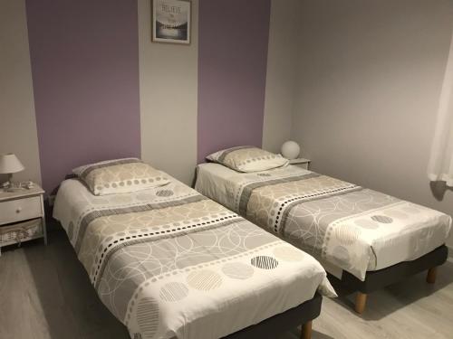 巴讷维尔-卡特里特Le Clos Des Pinsons的紫色墙壁的客房内的三张床