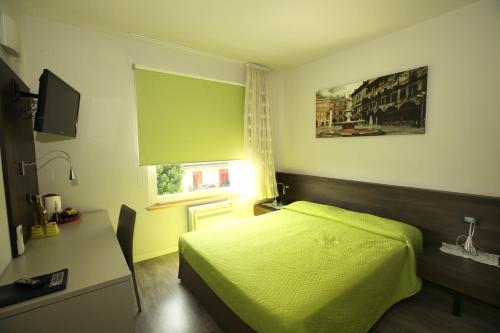 多索博诺艾桑提住宿加早餐旅馆的一间卧室配有一张床、一张书桌和一个窗户。