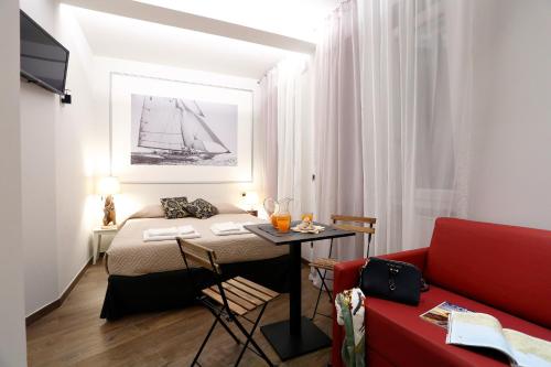 热那亚Gaslini e Sole的小房间设有一张床和一张红色的沙发
