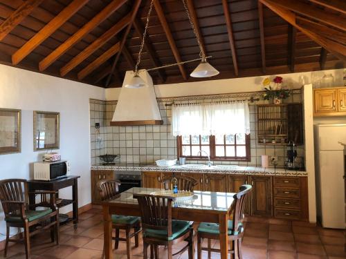 丰卡连特德拉帕尔马罗斯兰诺思内格罗斯乡村民宿的带桌椅的厨房和带吧台的厨房