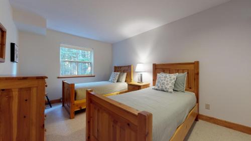惠斯勒Lush Forest and Golf Course Views by Harmony Whistler的一间卧室设有两张床和窗户。