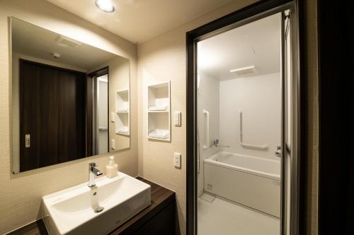京都Kyoto Central Inn的浴室配有盥洗盆、镜子和浴缸