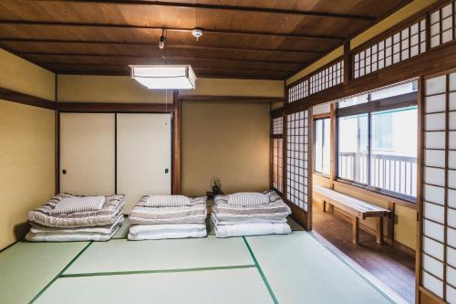 松江市KIAN the guest house的带四张床的客房,位于带窗户的房间内