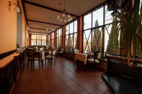 KlintsyUyut Centralnaya Hotel的餐厅设有桌椅和大窗户。