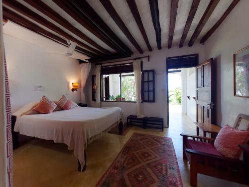 ShelaPeponi Hotel Lamu - Kenya的一间卧室设有一张床和一个大窗户
