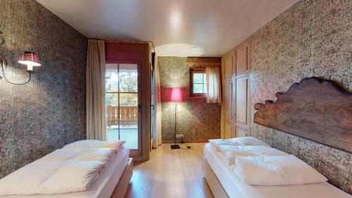 圣莫里茨Aruons的一间卧室设有两张床和大窗户