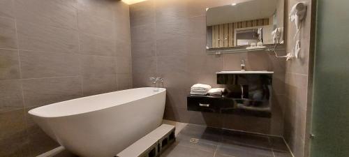 Ruifang永远是晴天民宿的浴室配有白色浴缸和水槽