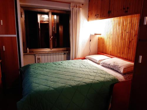 罗卡拉索Paradiso Aremogna的一间卧室设有一张绿色的床和一个窗户。