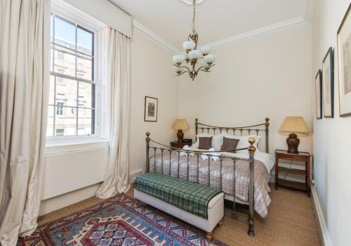 爱丁堡Parliament Sq (apt 10 ) Royal Mile的一间卧室设有一张床和一个窗口