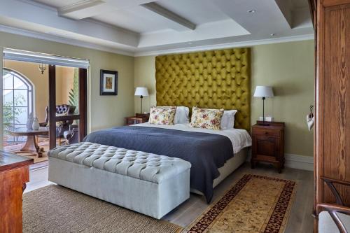 斯泰伦博斯Deux Frères Wine Estate & Luxury Villas的一间卧室设有一张大床和黄色的墙壁