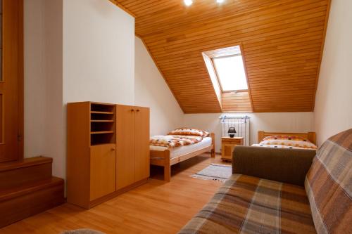 利普托斯基米库拉斯WOW Liptov Holiday House的阁楼间 - 带两张床和窗户