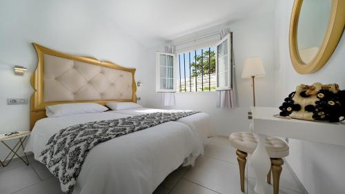 英格兰海滩阿多尼斯别墅酒店的白色的卧室设有一张大床和一个窗户