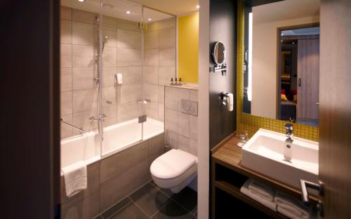 汉堡Holiday Inn - Hamburg - HafenCity, an IHG Hotel的带浴缸、卫生间和盥洗盆的浴室