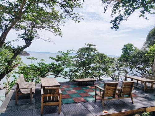 沙璜Beu Ceubeh Cottage Sabang的一个带桌椅的庭院,享有水景