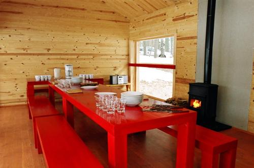 Upesciems阿尔伯塔迪克酒店的小木屋内的红色桌子,壁炉