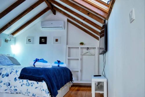 里斯本Casinha de Belém的一间卧室配有一张带蓝色棉被的床