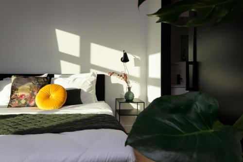 Koog aan de ZaanBoutique Hotel 43的一间卧室配有一张黄色枕头的床