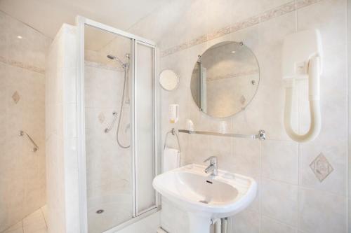 巴黎纳道酒店的白色的浴室设有水槽和淋浴。