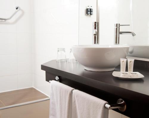 巴拉斯港Solace Hotel Puerto Varas的浴室配有盥洗盆和带毛巾的台面。