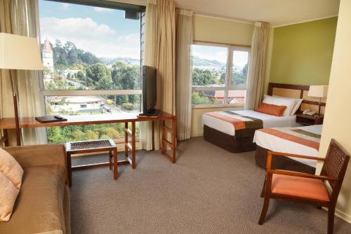 巴拉斯港Solace Hotel Puerto Varas的酒店客房设有两张床和大窗户。