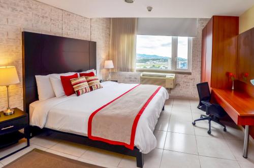 危地马拉Adriatika Hotel & Residence的酒店客房设有一张大床和一张书桌。