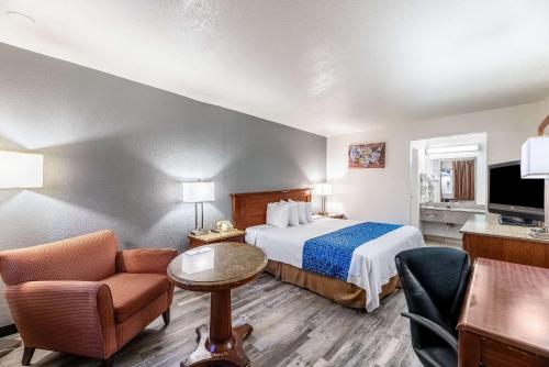 凤凰城Econo Lodge Phoenix North I-17的配有一张床和一把椅子的酒店客房