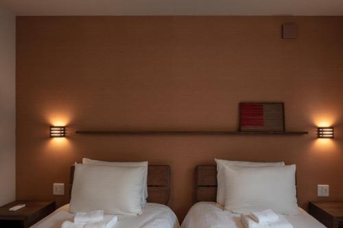 富良野MOKUREN的两张床位于带两盏灯的墙上。