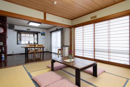 富士吉田市Guest house Fujinoyado Akebono - Vacation STAY 92428的客厅配有桌子和一些窗户