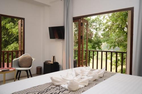 琅勃拉邦占城河景月光酒店的一间卧室设有一张床,享有阳台的景色